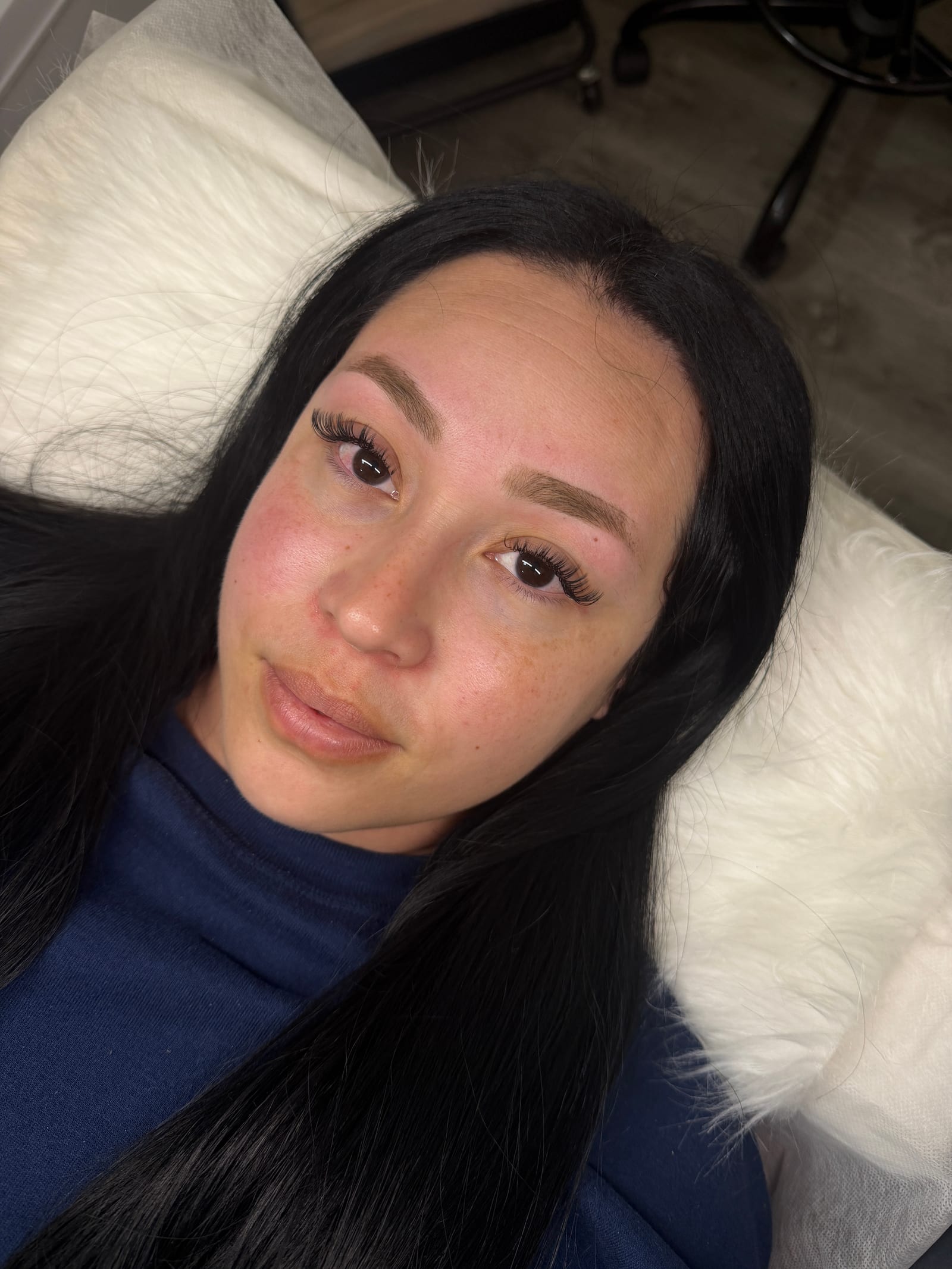 Reclining portrait showing a softly defined Classic lash set.