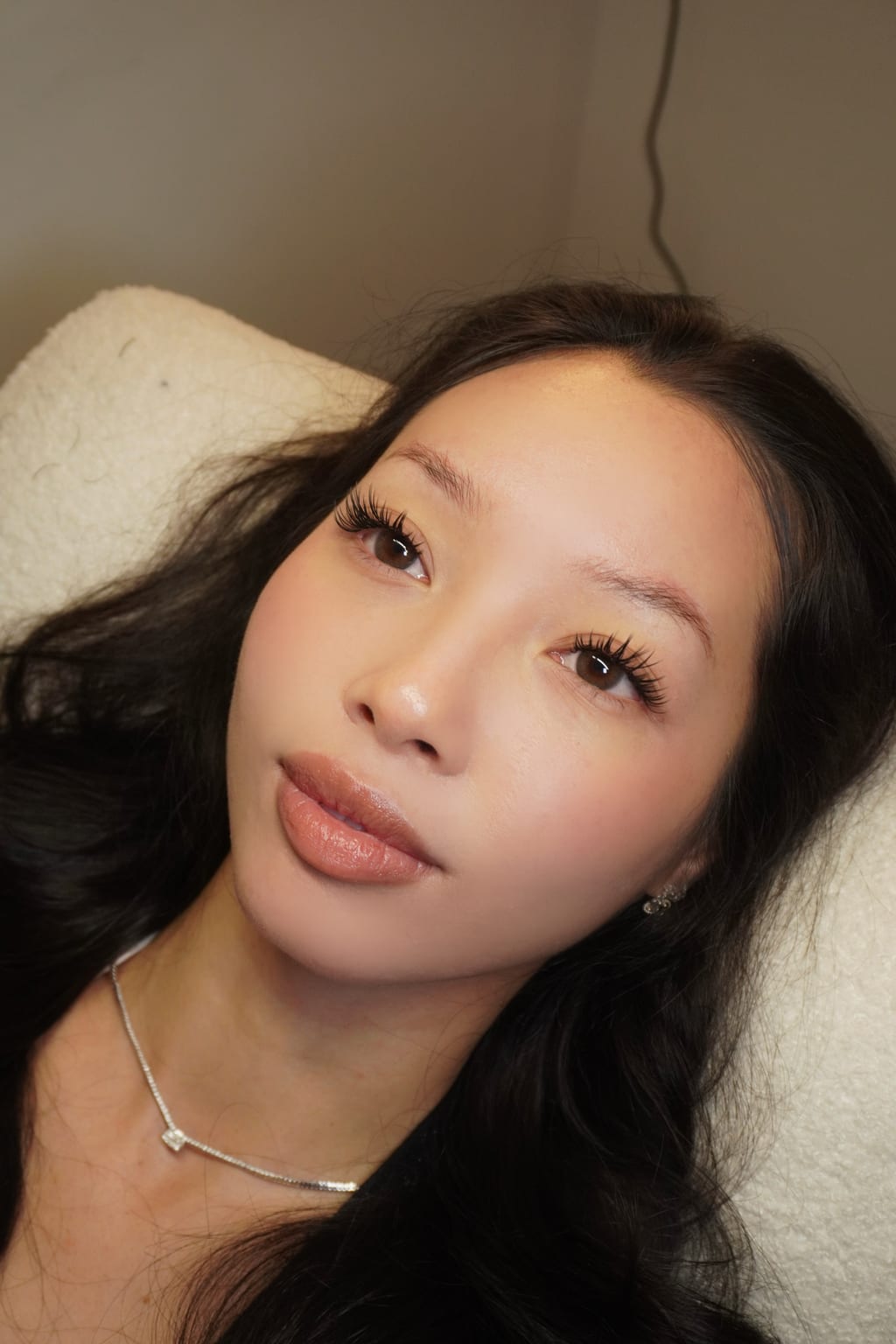 Reclining portrait showing a textured lash look.