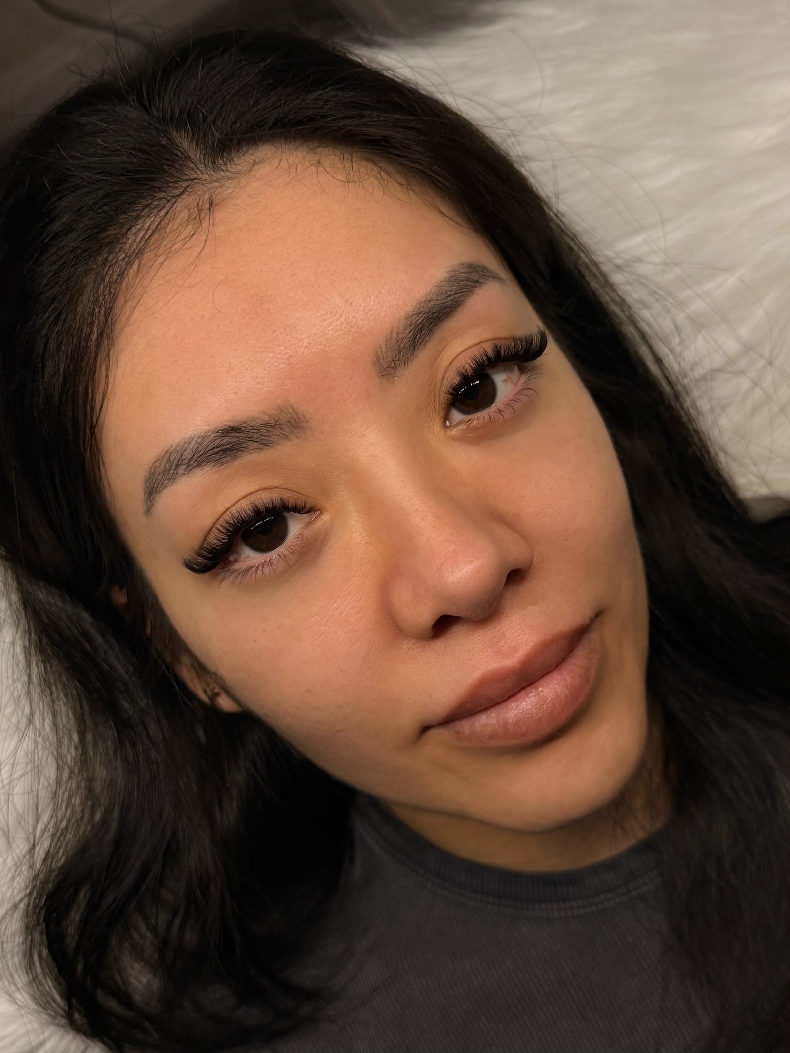 Reclining portrait showing a fuller Volume lash set.